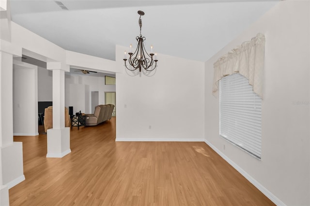 unfurnished dining area with hardwood / wood-style floors, ceiling fan with notable chandelier, and lofted ceiling