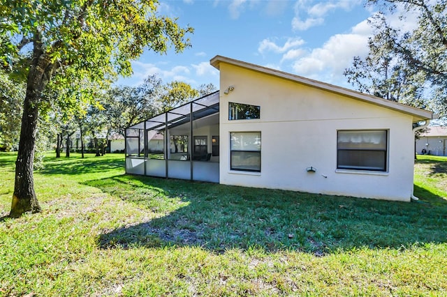 rear view of property featuring a lanai and a lawn