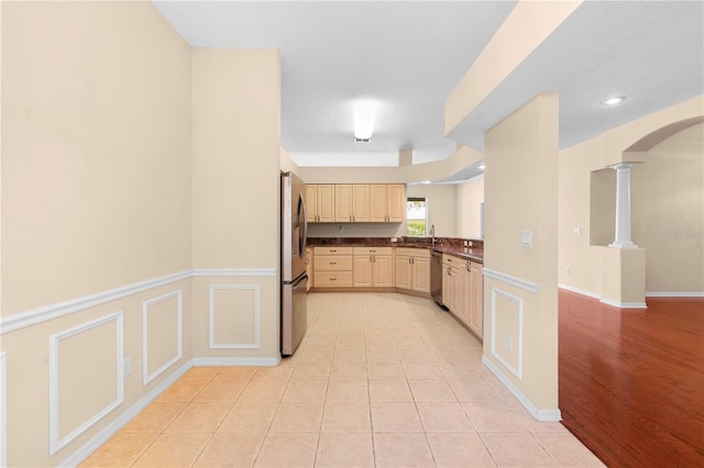 kitchen with ornate columns, light hardwood / wood-style flooring, stainless steel appliances, and a textured ceiling