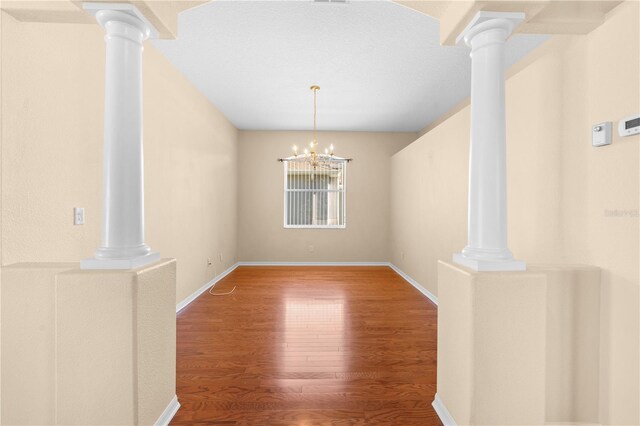 4201 Silver Berry Ct, Spring Hill, FL 34609 - unfurnished dining area with ornate columns, wood finished floors, and a chandelier