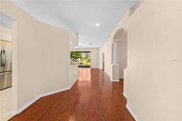 4201 Silver Berry Ct, Spring Hill, FL 34609 - corridor featuring arched walkways, wood finished floors, ornate columns, baseboards, and recessed lighting