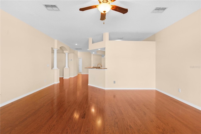 unfurnished living room with ceiling fan, sink, wood-type flooring, and a textured ceiling