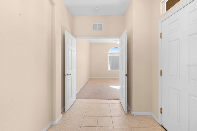 hallway featuring light colored carpet