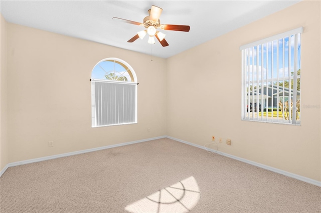 carpeted spare room featuring ceiling fan