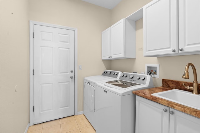 laundry room with washer and clothes dryer, cabinets, light tile patterned floors, and sink