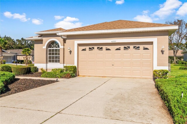4201 Silver Berry Ct, Spring Hill, FL 34609 - view of front of home with stucco siding, an attached garage, and concrete driveway