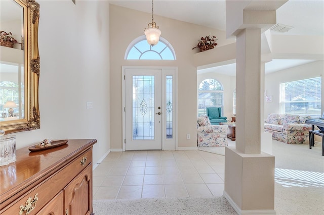 foyer entrance with plenty of natural light, light tile patterned flooring, and lofted ceiling