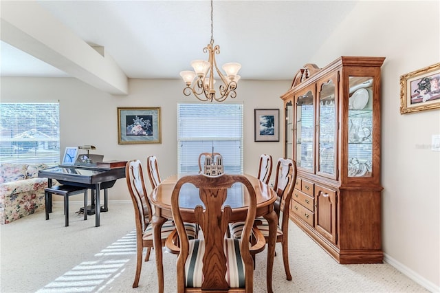 dining room featuring light carpet and a chandelier