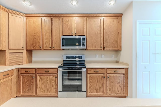 kitchen with a textured ceiling and appliances with stainless steel finishes