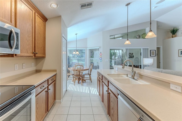 kitchen featuring pendant lighting, sink, stainless steel appliances, and lofted ceiling