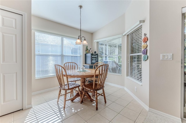 dining space with light tile patterned floors, an inviting chandelier, and lofted ceiling