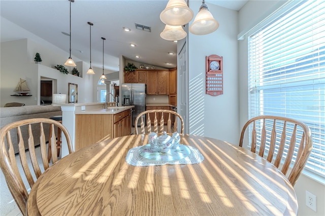 dining space featuring sink and vaulted ceiling