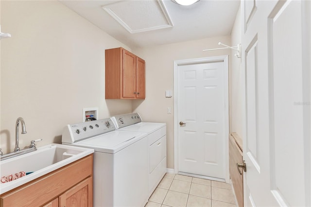 laundry area featuring cabinets, light tile patterned floors, sink, and washing machine and clothes dryer