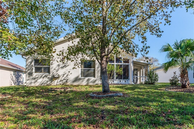 rear view of property with a sunroom and a yard