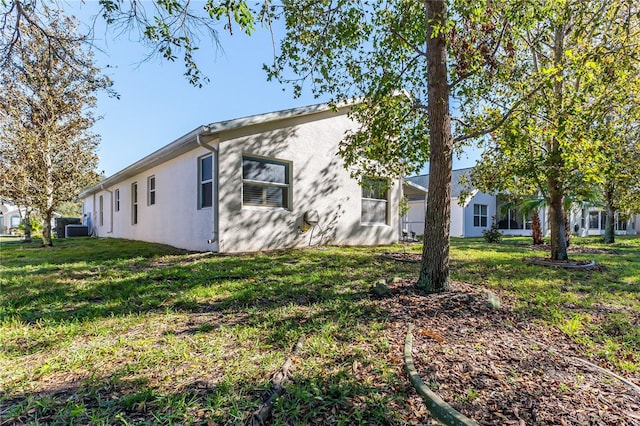 view of side of home with a yard and central AC unit