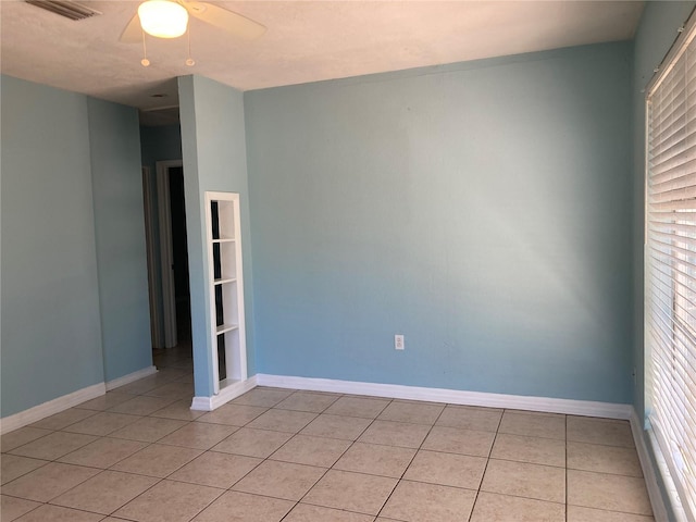 unfurnished room with ceiling fan and light tile patterned flooring