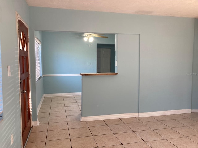 spare room featuring light tile patterned floors and ceiling fan