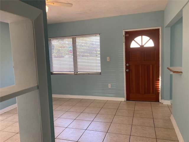 tiled foyer entrance featuring ceiling fan and a textured ceiling