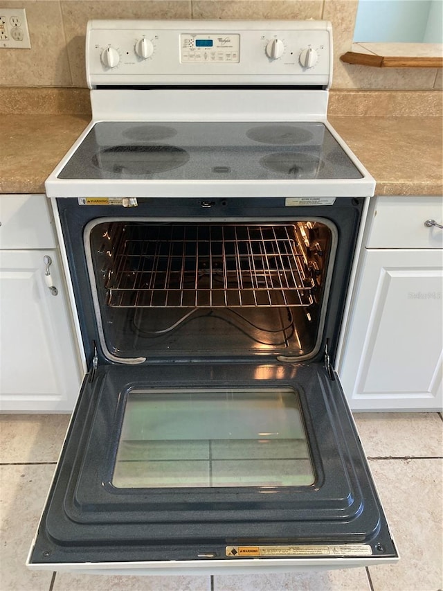 room details with electric range oven and white cabinetry