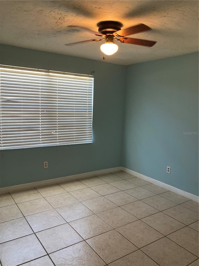 tiled spare room featuring a textured ceiling and ceiling fan