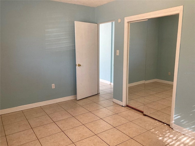 unfurnished bedroom with light tile patterned floors and a closet