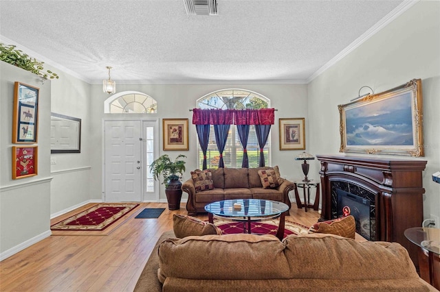 living room with crown molding, a premium fireplace, a textured ceiling, and hardwood / wood-style flooring