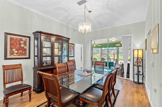 dining area featuring light hardwood / wood-style flooring, a chandelier, and ornamental molding