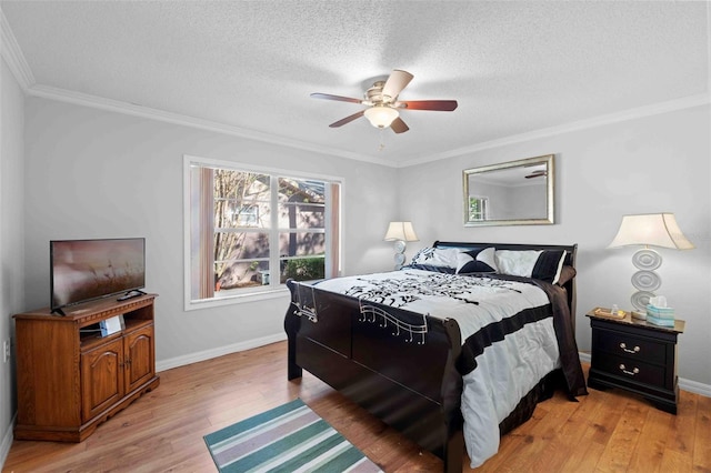 bedroom featuring ceiling fan, crown molding, light wood-type flooring, and a textured ceiling