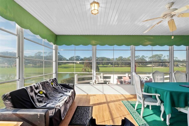 sunroom / solarium with a water view and ceiling fan