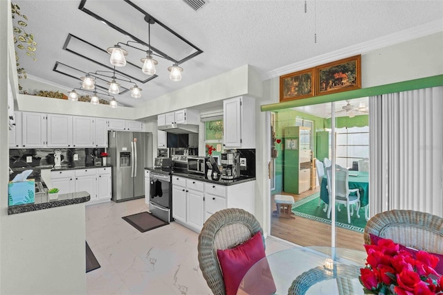 kitchen featuring backsplash, ornamental molding, a textured ceiling, white cabinetry, and stainless steel appliances