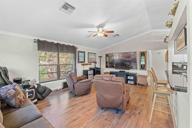 living room featuring ornamental molding, light hardwood / wood-style flooring, ceiling fan, and lofted ceiling