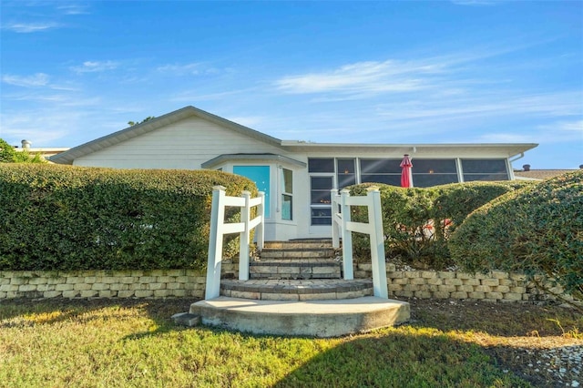 view of exterior entry with a lawn