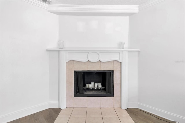 details with a tile fireplace, hardwood / wood-style floors, and ornamental molding