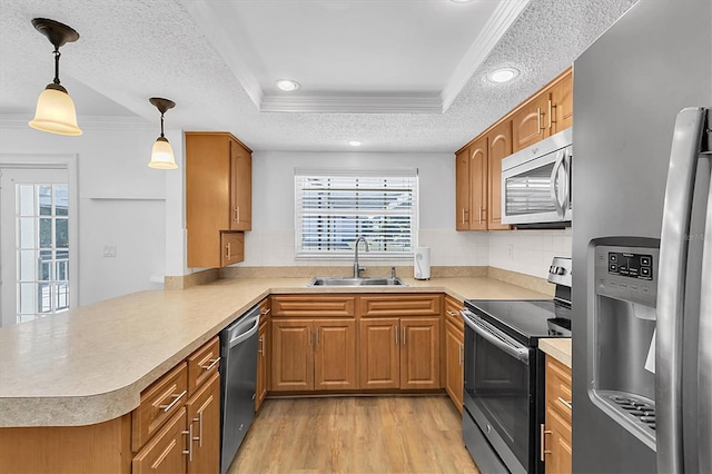 kitchen with kitchen peninsula, a textured ceiling, stainless steel appliances, sink, and hanging light fixtures