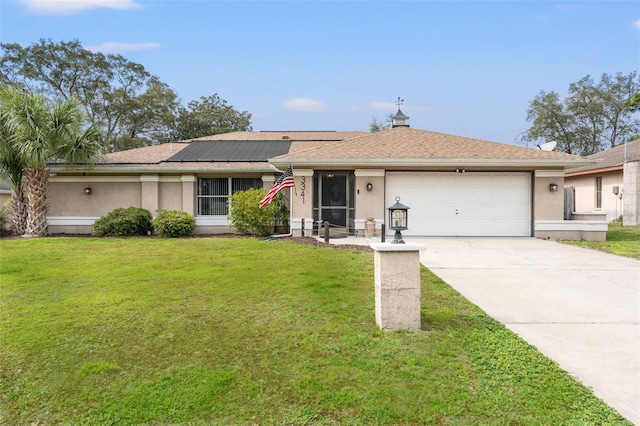 ranch-style home with a front yard, solar panels, and a garage