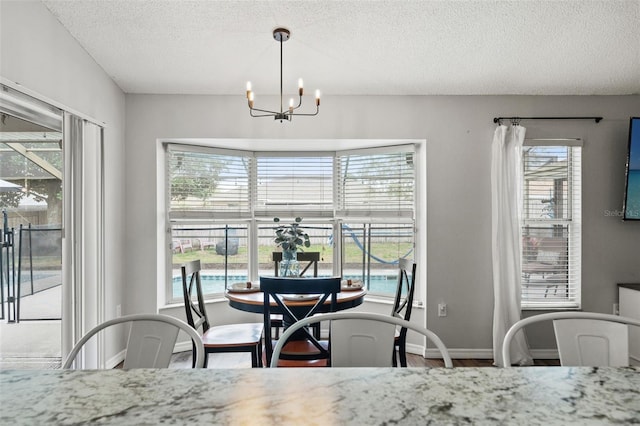 dining room with hardwood / wood-style floors, a textured ceiling, and an inviting chandelier