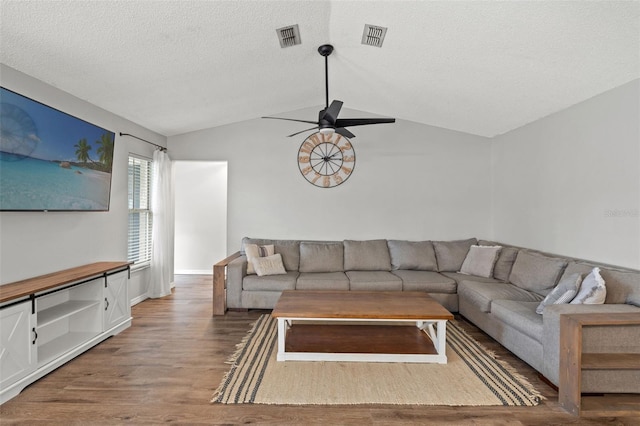 living room with a textured ceiling, ceiling fan, vaulted ceiling, and hardwood / wood-style flooring