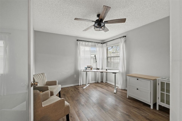 living area with a textured ceiling, dark hardwood / wood-style flooring, and ceiling fan