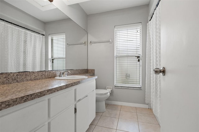 bathroom featuring tile patterned floors, a wealth of natural light, vanity, and toilet