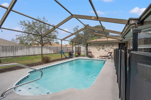 view of pool with a patio, glass enclosure, and a shed