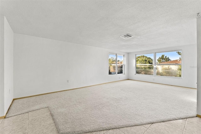 tiled spare room with a textured ceiling