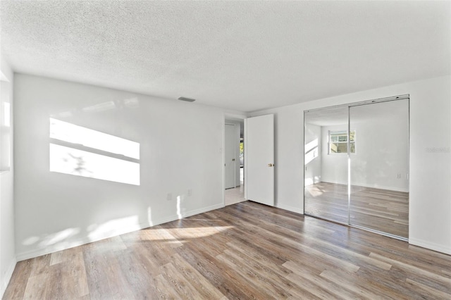 empty room featuring hardwood / wood-style flooring and a textured ceiling