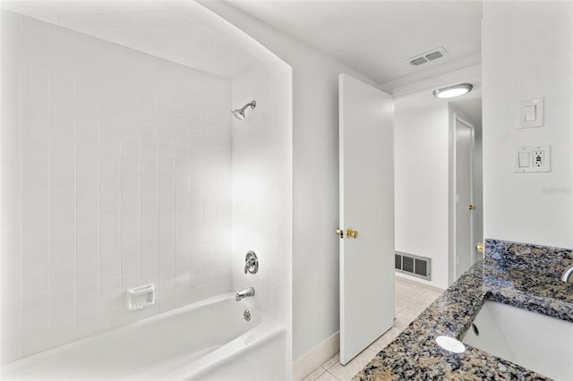 bathroom featuring tile patterned flooring, vanity, and tiled shower / bath