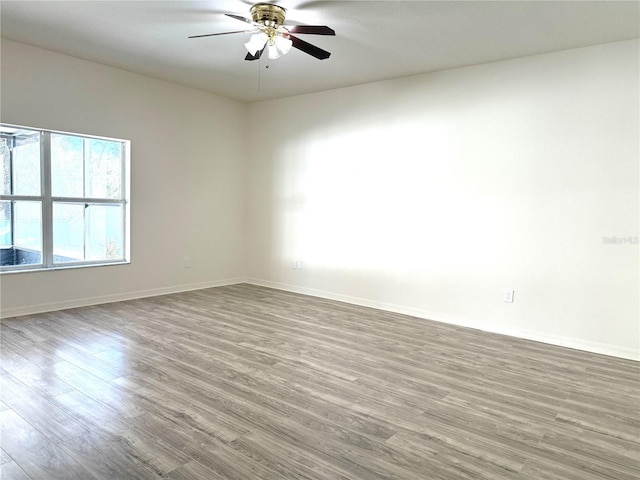 spare room featuring baseboards, a ceiling fan, and wood finished floors