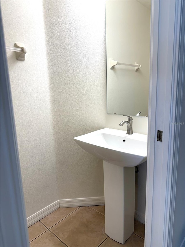 bathroom featuring a sink, tile patterned flooring, and baseboards