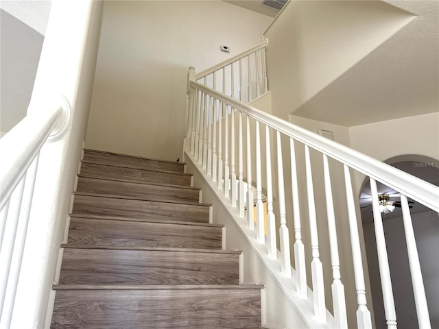 staircase featuring visible vents and a ceiling fan