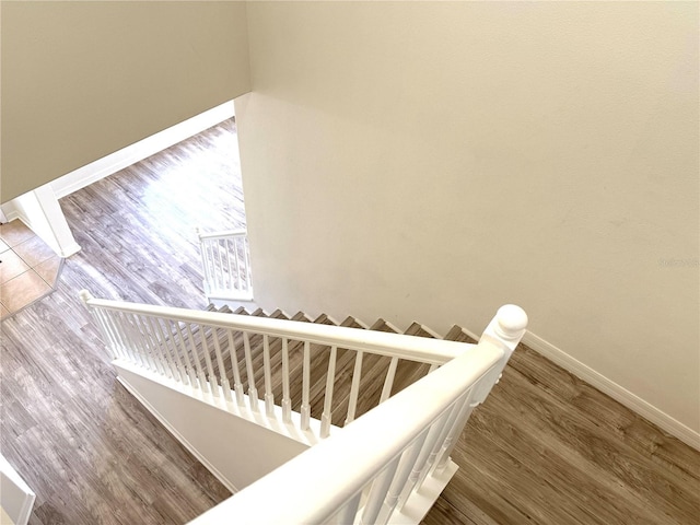 staircase featuring baseboards and wood finished floors