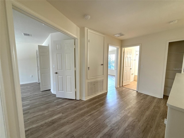 empty room featuring visible vents and dark wood-type flooring