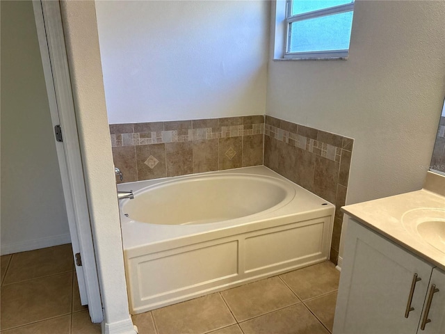 bathroom with a garden tub, tile patterned flooring, and vanity