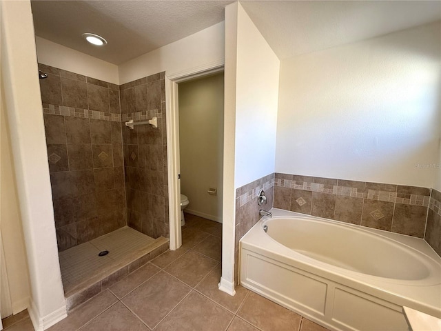 bathroom featuring tile patterned floors, a garden tub, toilet, and tiled shower